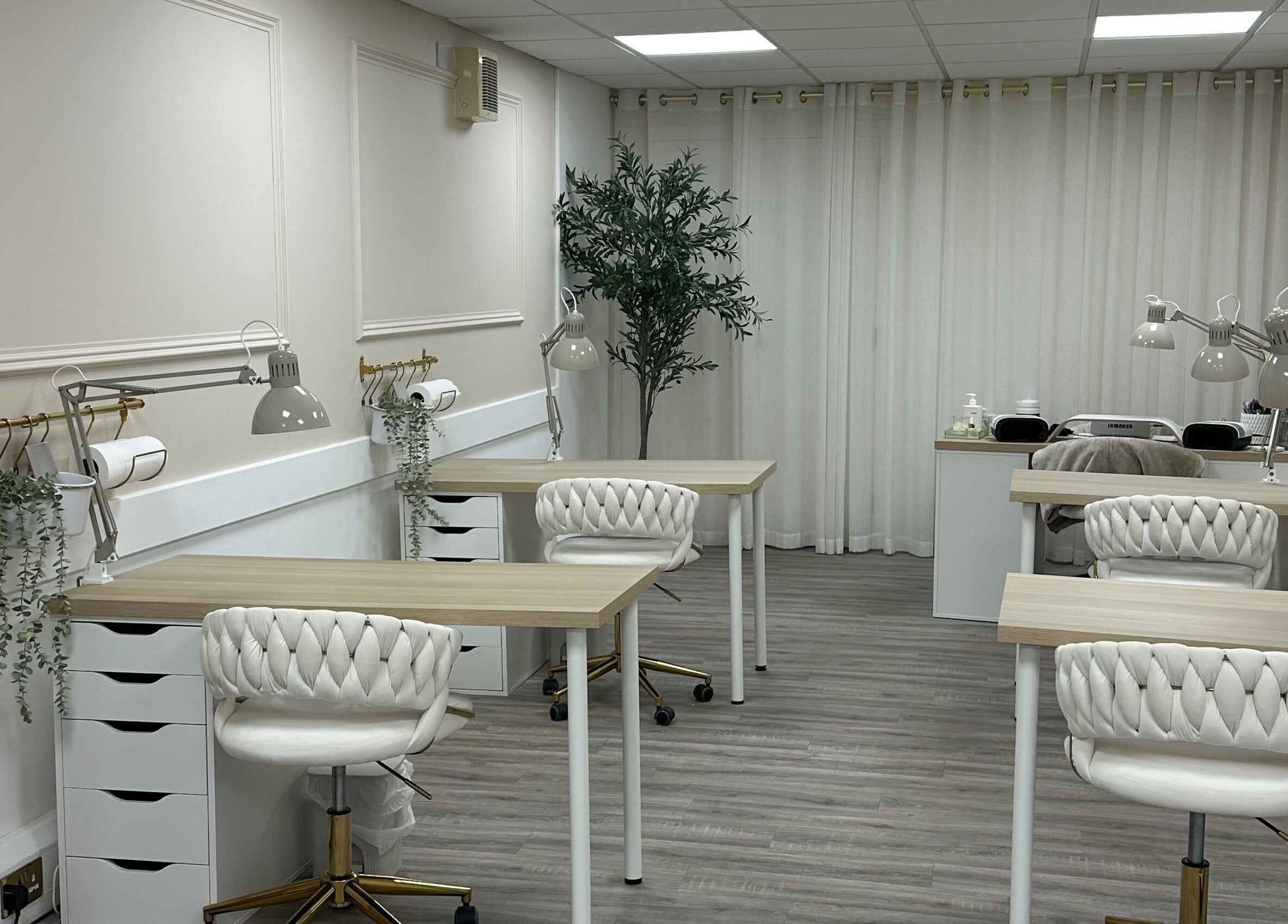 Serene interior of Olive Nails Studio in Kilmarnock, Scotland, GB with stylish chairs and wooden desks.