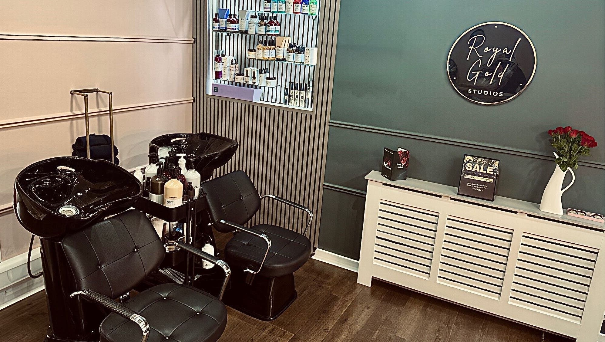 Chic salon space at Royal Gold Studios, Mullingar, County Westmeath, IE showcasing modern styling chairs and product wall.