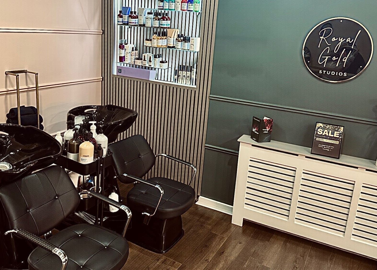 Chic salon space at Royal Gold Studios, Mullingar, County Westmeath, IE showcasing modern styling chairs and product wall.