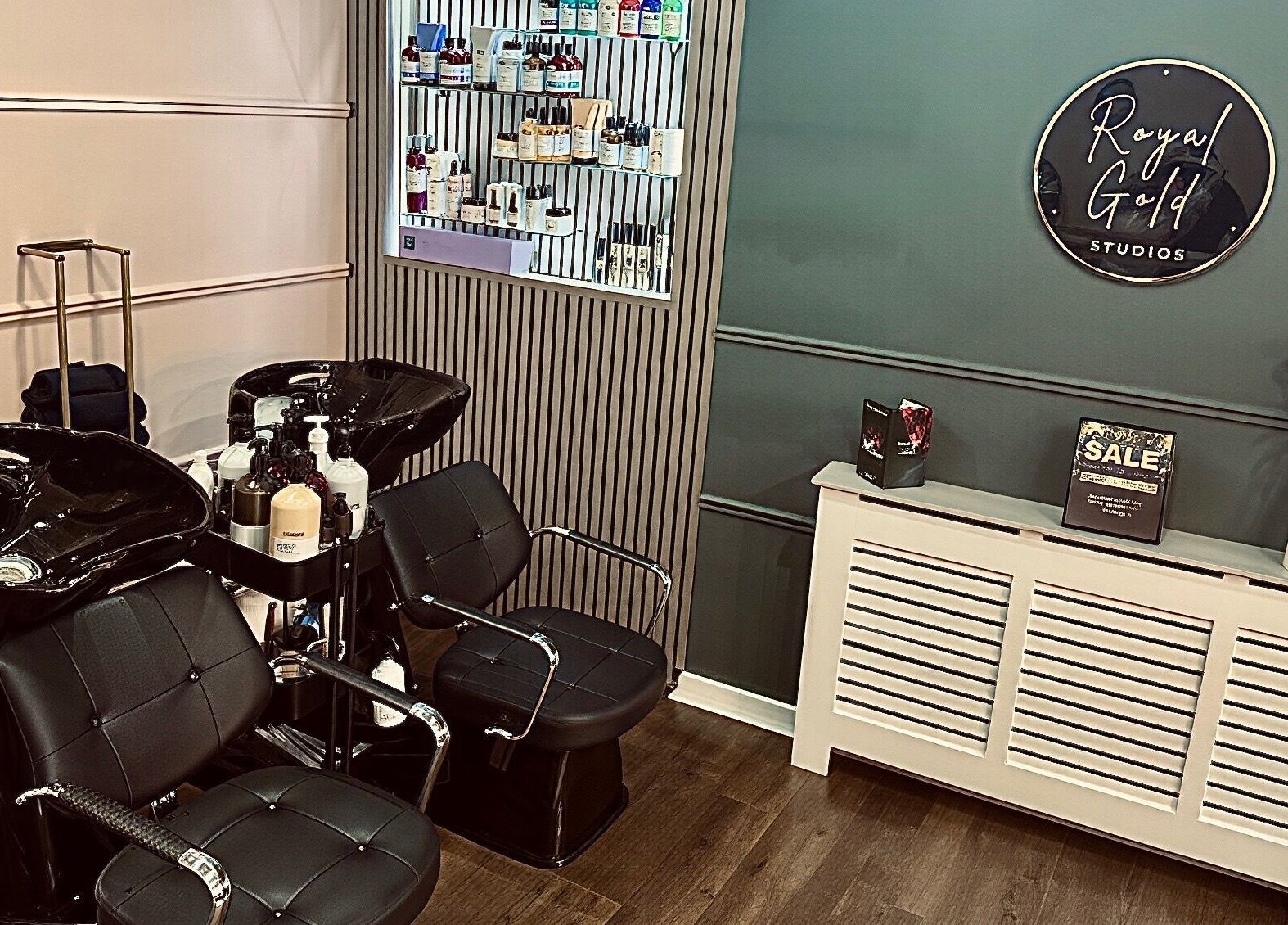 Chic salon space at Royal Gold Studios, Mullingar, County Westmeath, IE showcasing modern styling chairs and product wall.