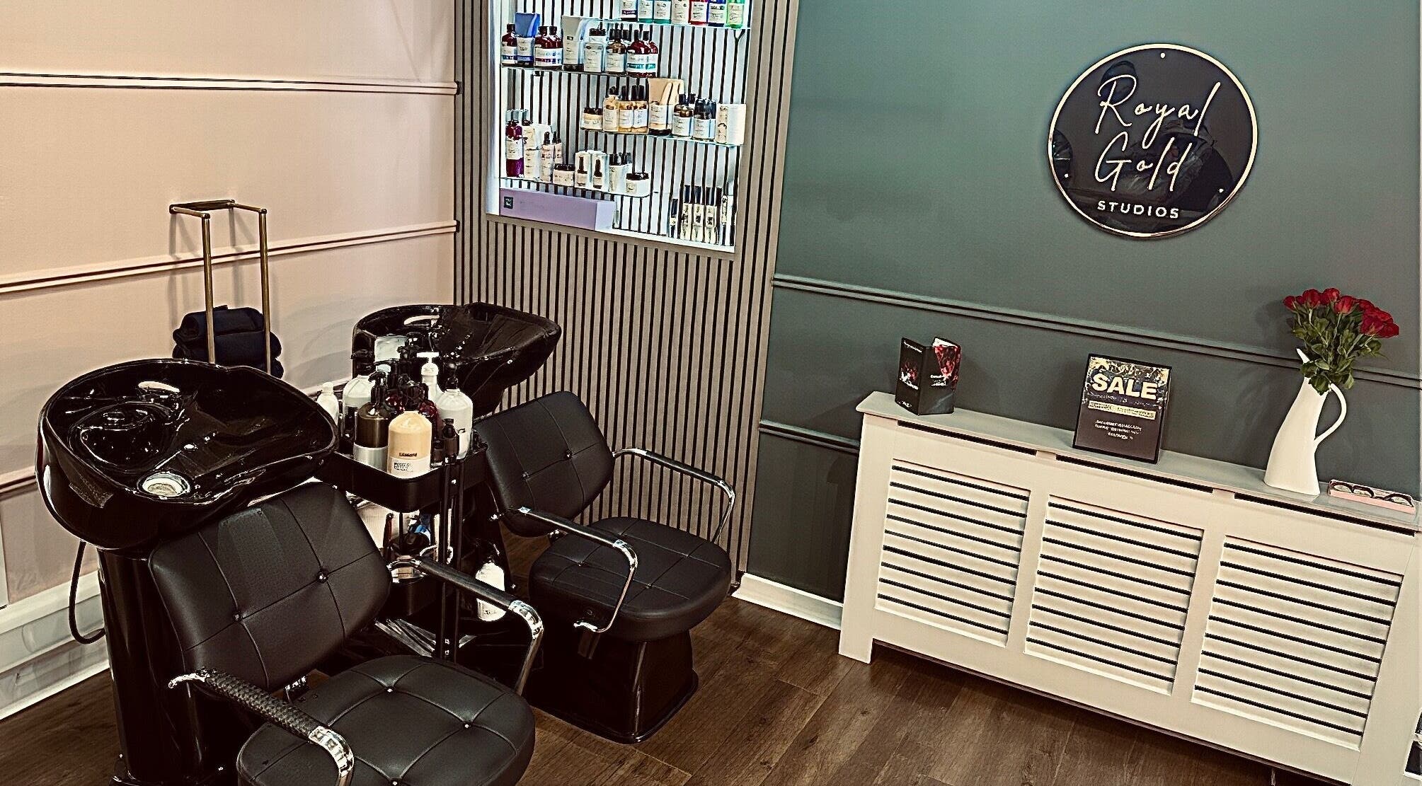 Chic salon space at Royal Gold Studios, Mullingar, County Westmeath, IE showcasing modern styling chairs and product wall.