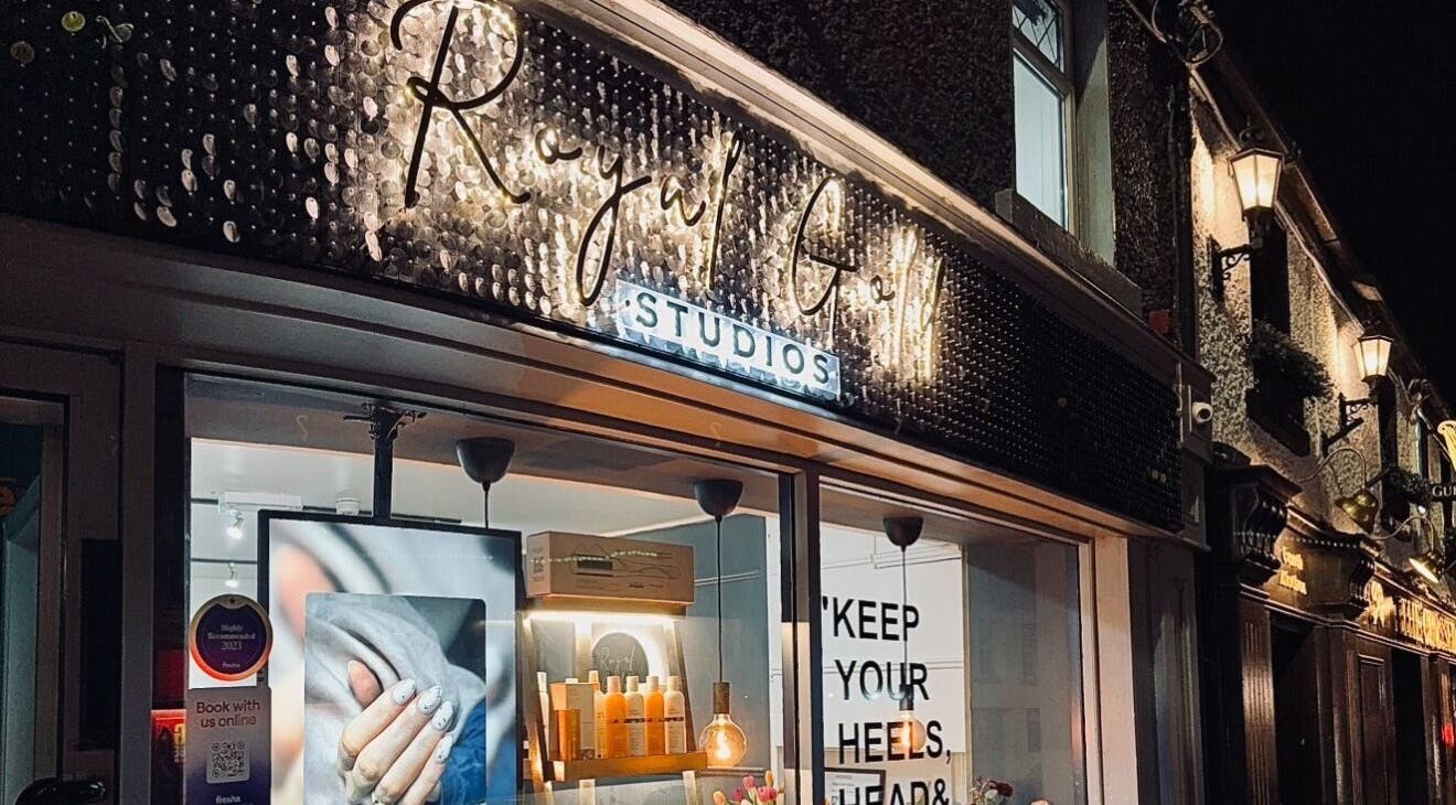 Illuminated facade of Royal Gold Studios, Mullingar, County Westmeath, IE at night showcasing beauty services.