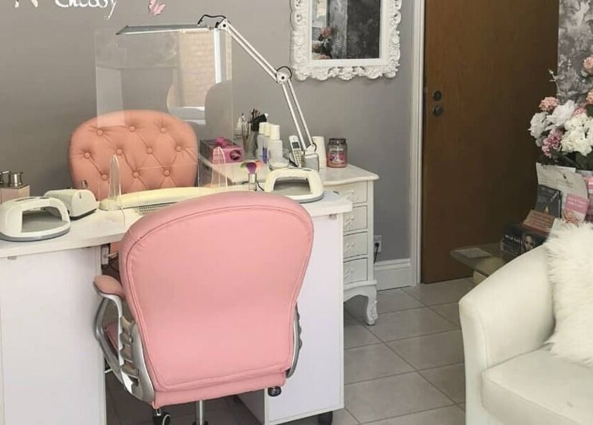 Sophisticated nail station at Glam N Glossy, South Woodham Ferrers, England, featuring a pink chair and elegant decor.