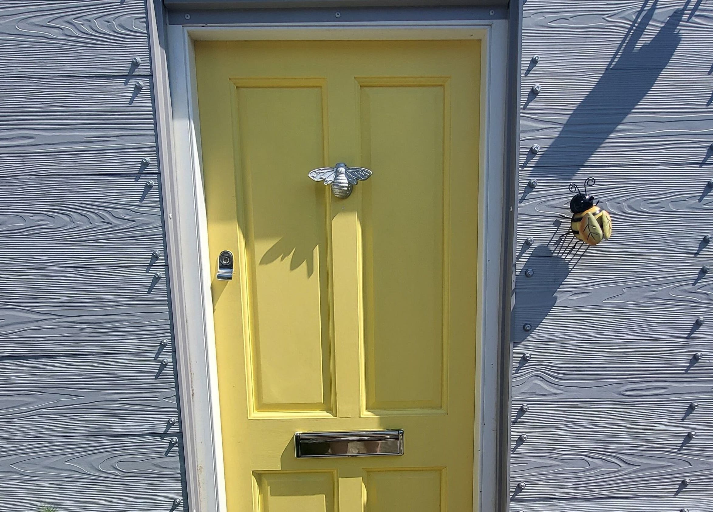 Yellow door with bee decor at CCB Nails and Beauty, Basingstoke, England, GB.