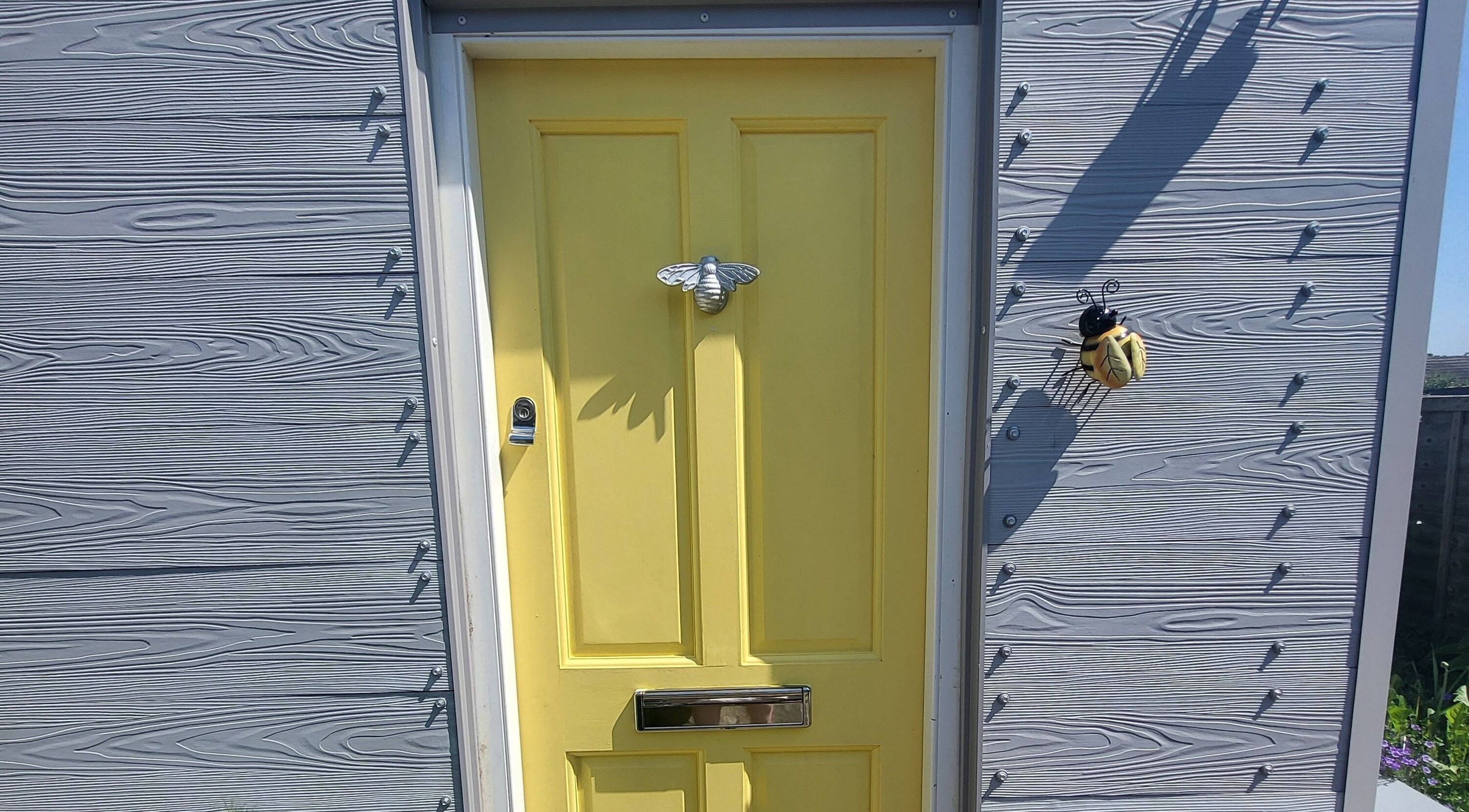 Yellow door with bee decor at CCB Nails and Beauty, Basingstoke, England, GB.