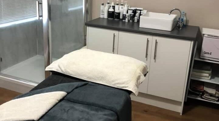 Treatment room at Skin and Tonic Barnsley, Birdwell, England, GB, featuring a massage bed and skincare products.