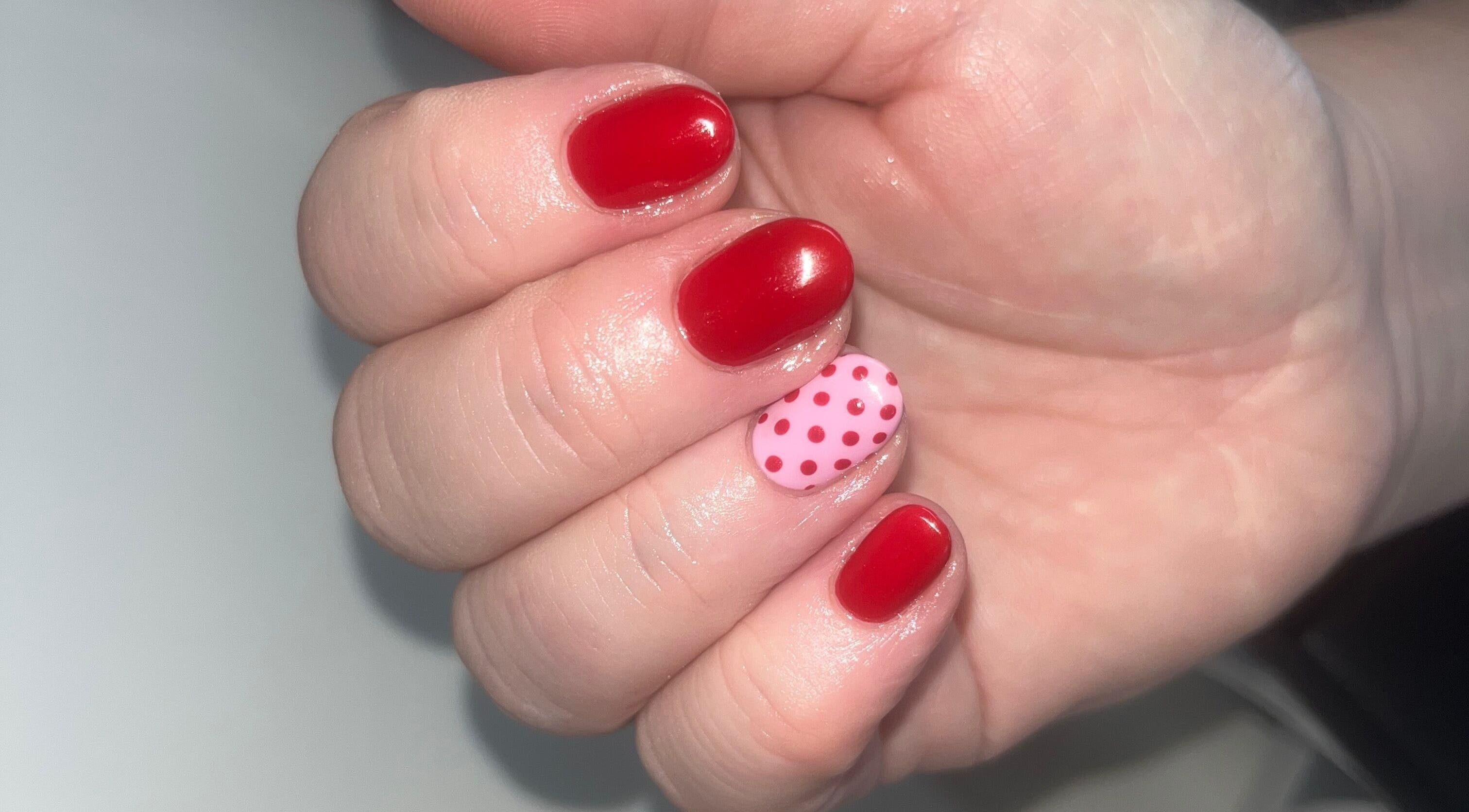 Stylish red and pink polka dot nails at Beauty Spot by Naomi, Adlington, England, GB.