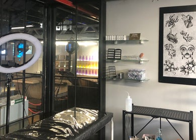 Interior of Jane-Doe Ink Kramerville in Sandton, Gauteng, ZA: tattoo chair, art, and ring light.