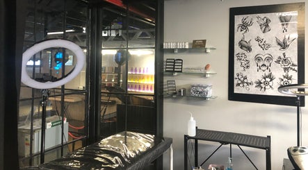 Interior of Jane-Doe Ink Kramerville in Sandton, Gauteng, ZA: tattoo chair, art, and ring light.