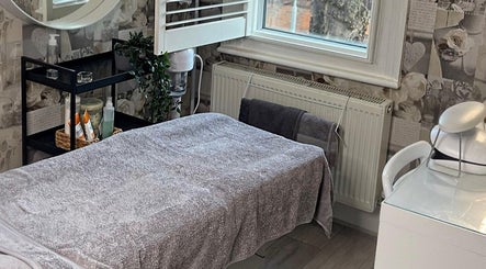 Tranquil treatment room at AJ Beauty Studio, Hucknall, England, GB with massage table and spa decor.