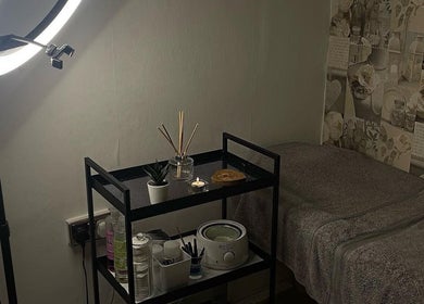 AJ Beauty Studio in Hucknall, England: stylish beauty treatment room with a ring light and organized supplies.