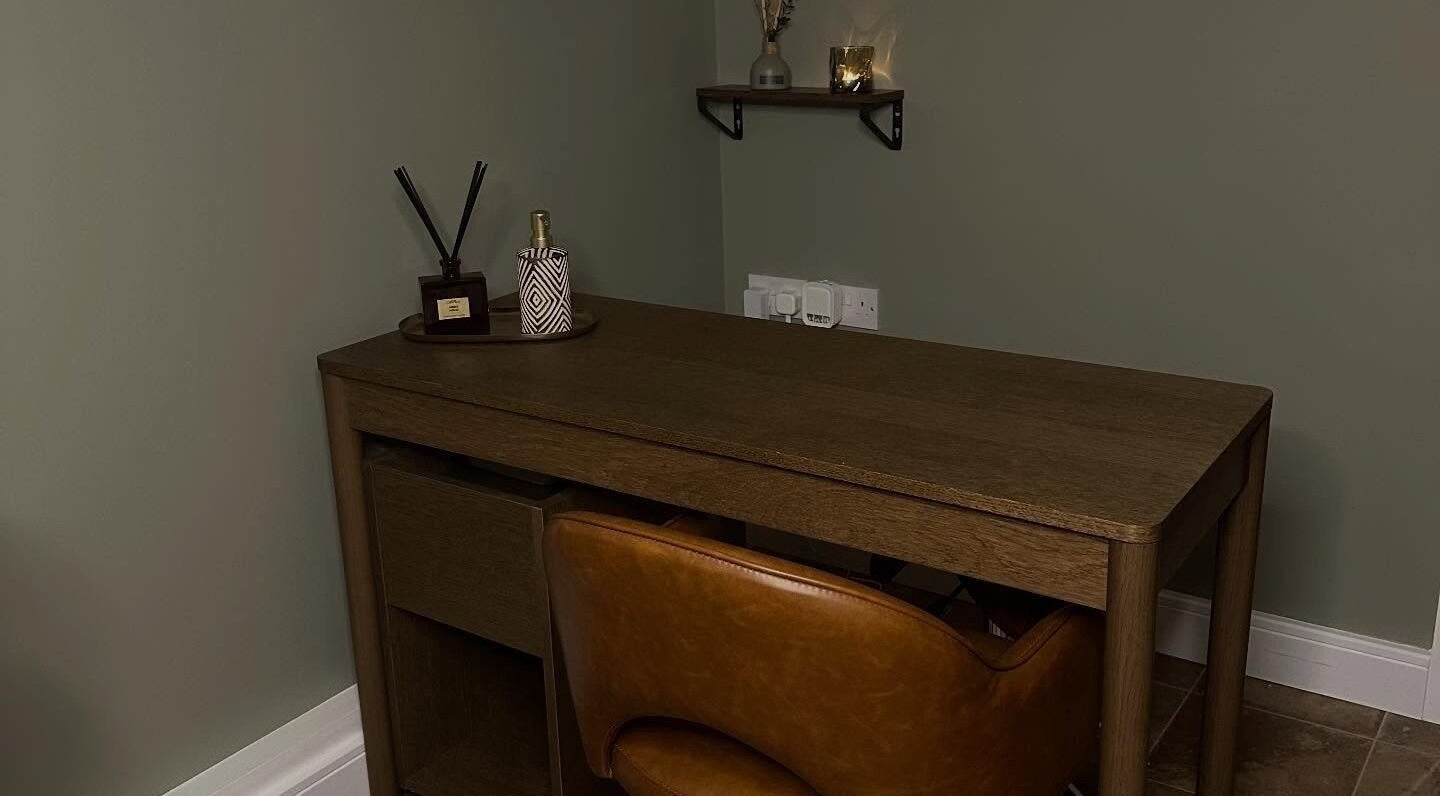 Elegant brown desk with decor in AJ Beauty Studio, Hucknall, England, GB. A cozy and inviting workspace.