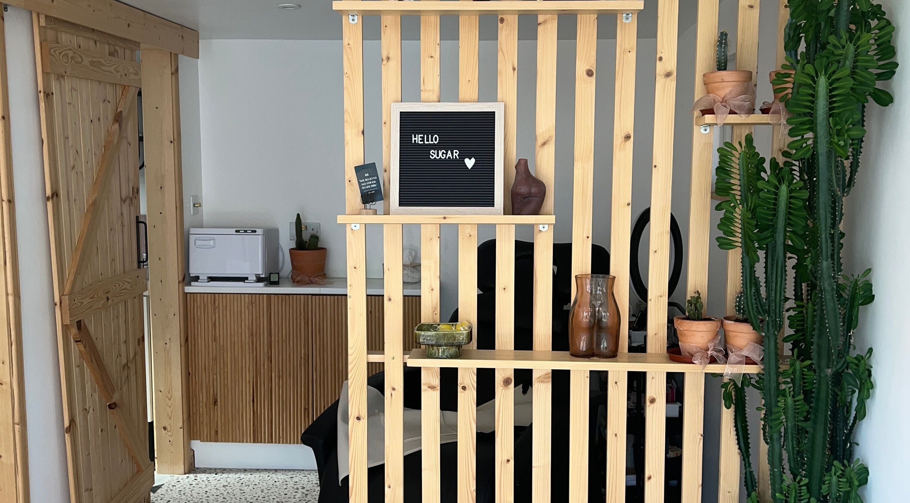 Cozy interior of Sugared by Shola in Bristol, England, GB with wooden accents and lush greenery.
