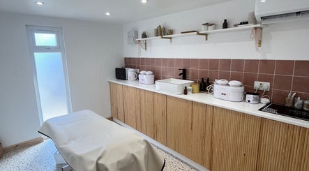 Cozy treatment room at Sugared by Shola in Bristol, England, GB, featuring warm tones and modern decor.