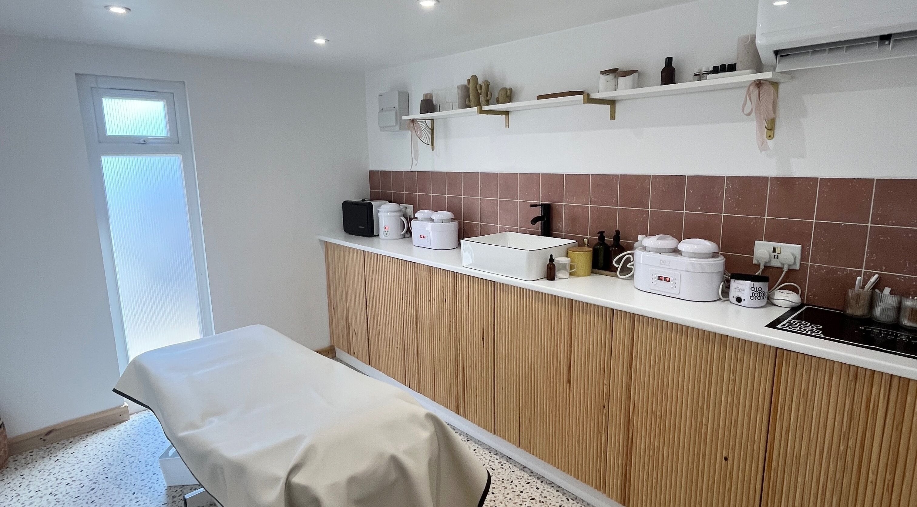 Cozy treatment room at Sugared by Shola in Bristol, England, GB, featuring warm tones and modern decor.