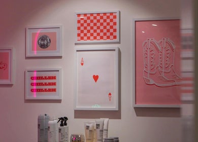 Framed art and hair products at Maddi Jane Hair Studio in Southport, Queensland, AU. Stylish decor and ambiance.