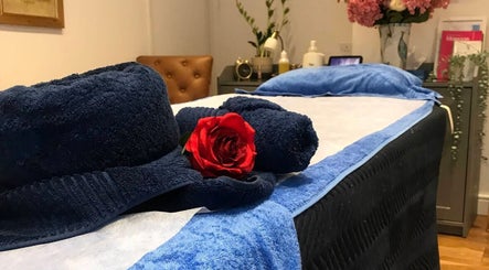 Relaxing massage table setup at Thawee Thai Therapy in Shirley, England, GB with towels and a red rose.