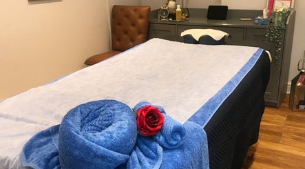 Relaxing massage table at Thawee Thai Therapy, Shirley, England, GB, adorned with blue towels and a red rose.