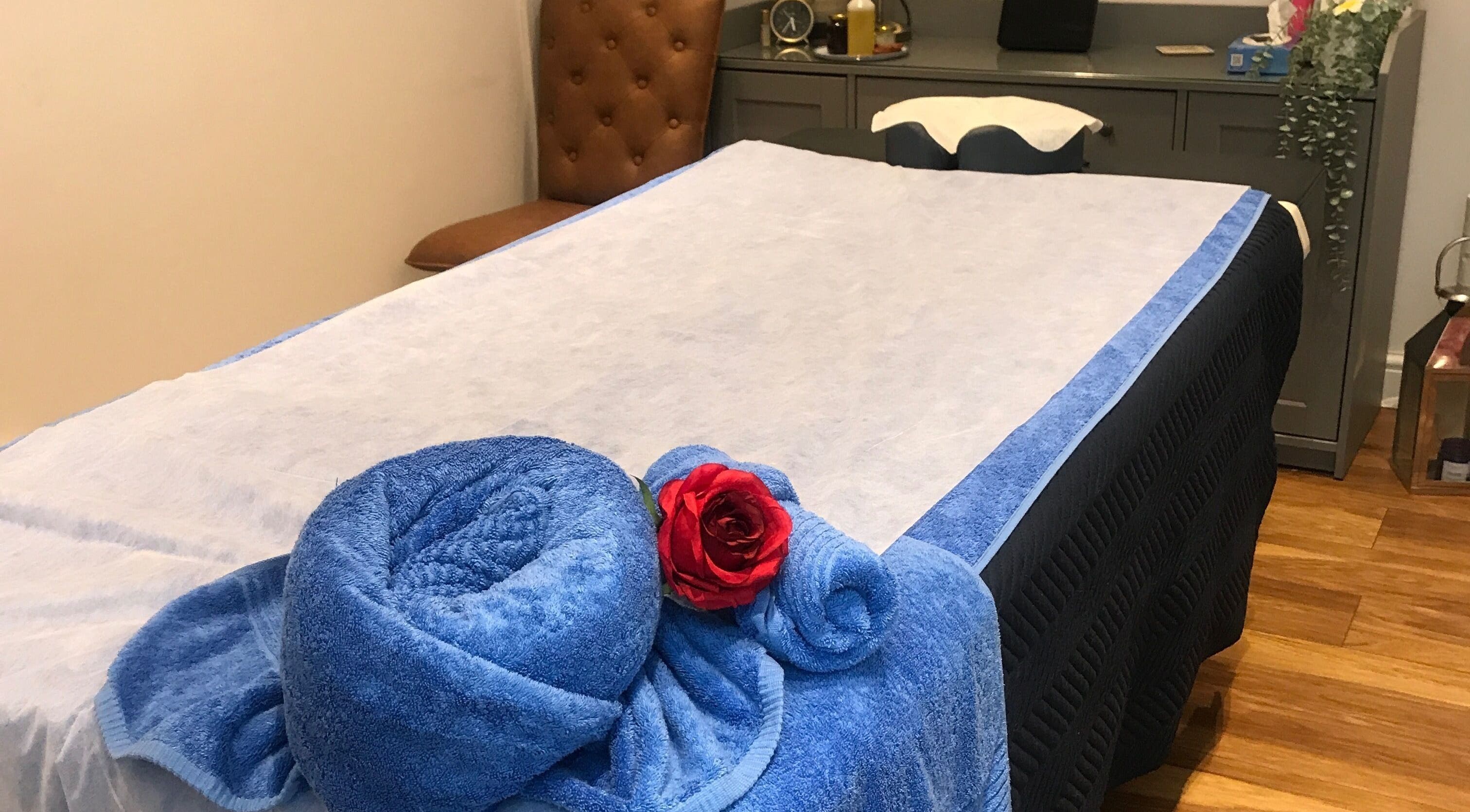 Massage table with blue linens and a red rose at Thawee Thai Therapy, Shirley, England, GB.