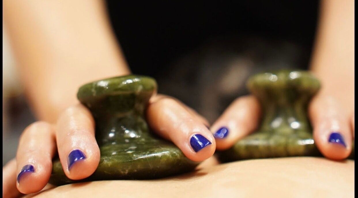 Close-up of hands using herbal stones in a massage at Thawee Thai Therapy, Shirley, England, GB.