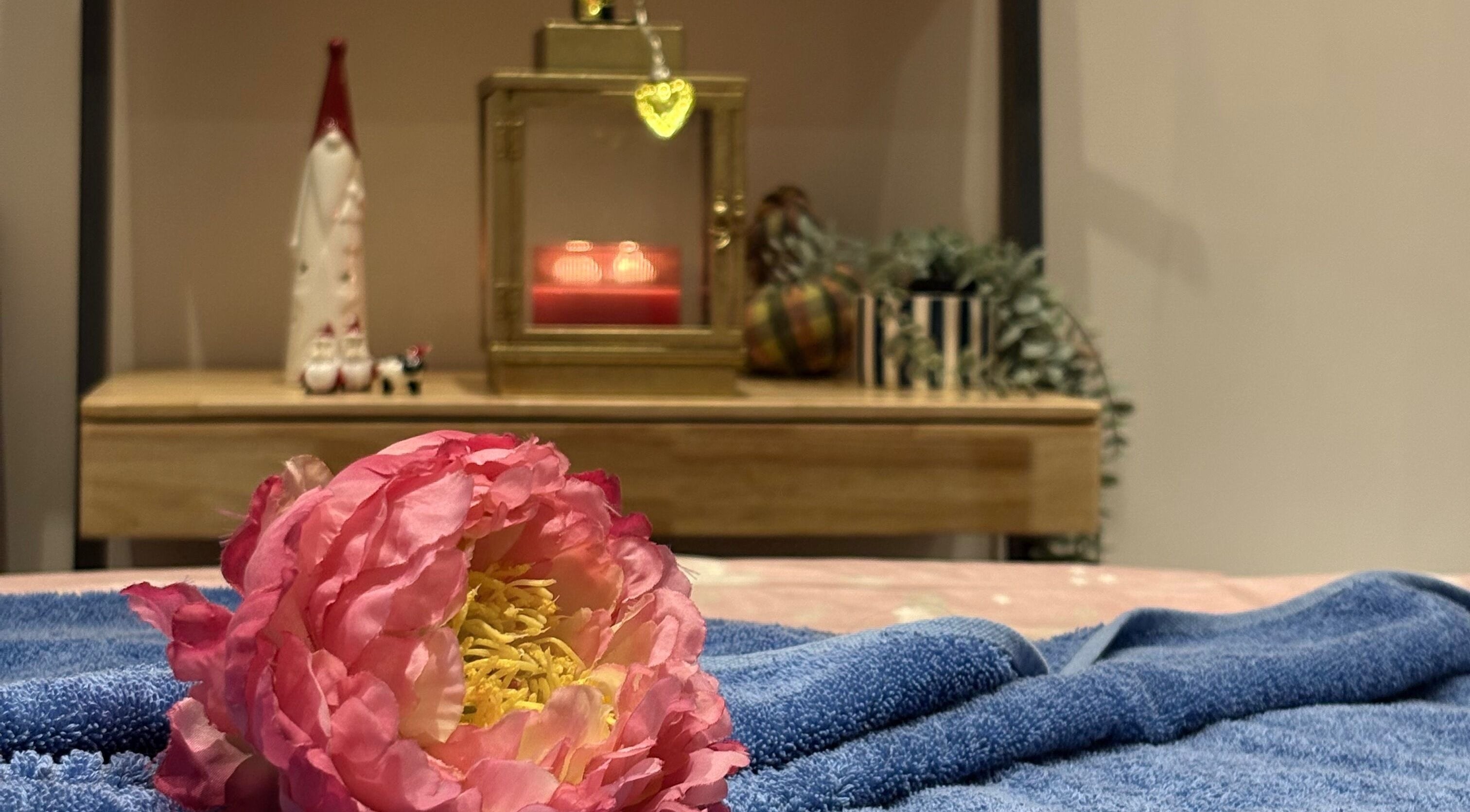 Cozy setting with pink flower and candle at Thawee Thai Therapy, Shirley, England, GB.