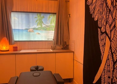 Tranquil massage room at Wellness at Happy Buddha, Poole, England, GB with ocean window view and Buddha statue.