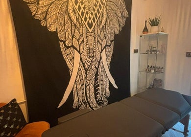 Relaxing massage room at Wellness at Happy Buddha, Poole, England, GB, featuring a detailed elephant tapestry.