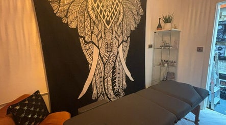 Relaxing massage room at Wellness at Happy Buddha, Poole, England, GB, featuring a detailed elephant tapestry.