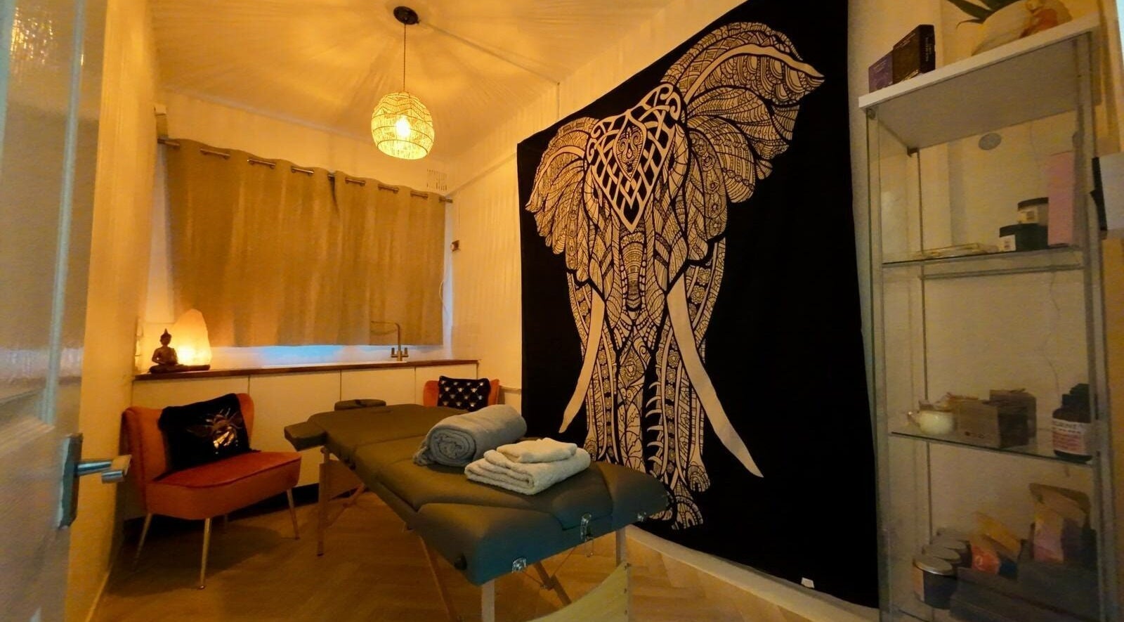 Tranquil massage room at Wellness at Happy Buddha in Poole, England, GB featuring a majestic elephant tapestry.