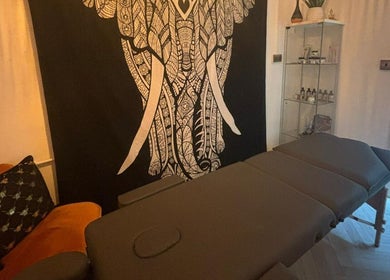 Relaxing massage room at Wellness at Happy Buddha in Poole, England, GB featuring an elephant tapestry.