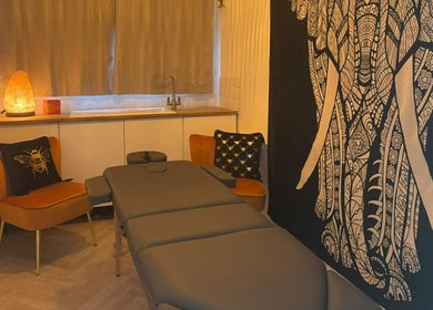 Relaxing massage room at Wellness at Happy Buddha, Poole, England, GB with warm lighting and elegant decor.