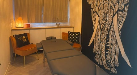 Relaxing massage room at Wellness at Happy Buddha, Poole, England, GB with warm lighting and elegant decor.