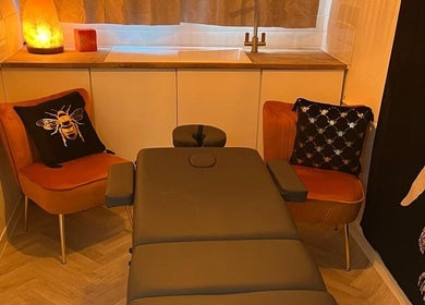 Cozy wellness room at Wellness at Happy Buddha, Poole, England, GB, featuring a massage table and warm lighting.