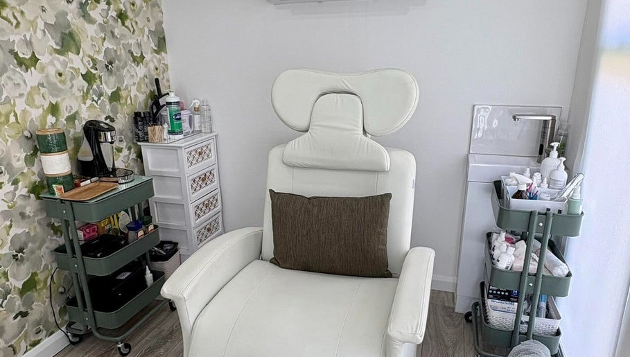 Relaxing therapy chair at Therapy Beauty, Wakefield, England, GB, with floral wall and modern decor.