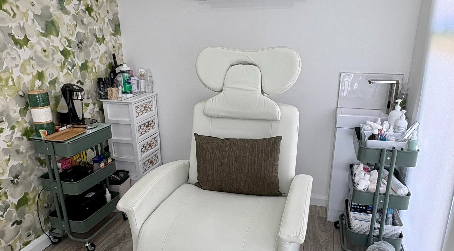 Modern beauty treatment chair at Therapy Beauty, Wakefield, England, GB, with floral decor and wellness supplies.