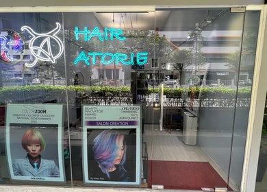 Front entrance of Hair Atorie, a stylish salon in Singapore, SG featuring vibrant awards display.
