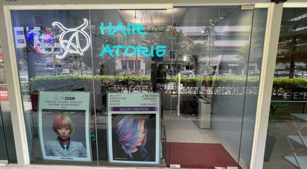 Front entrance of Hair Atorie, a stylish salon in Singapore, SG featuring vibrant awards display.