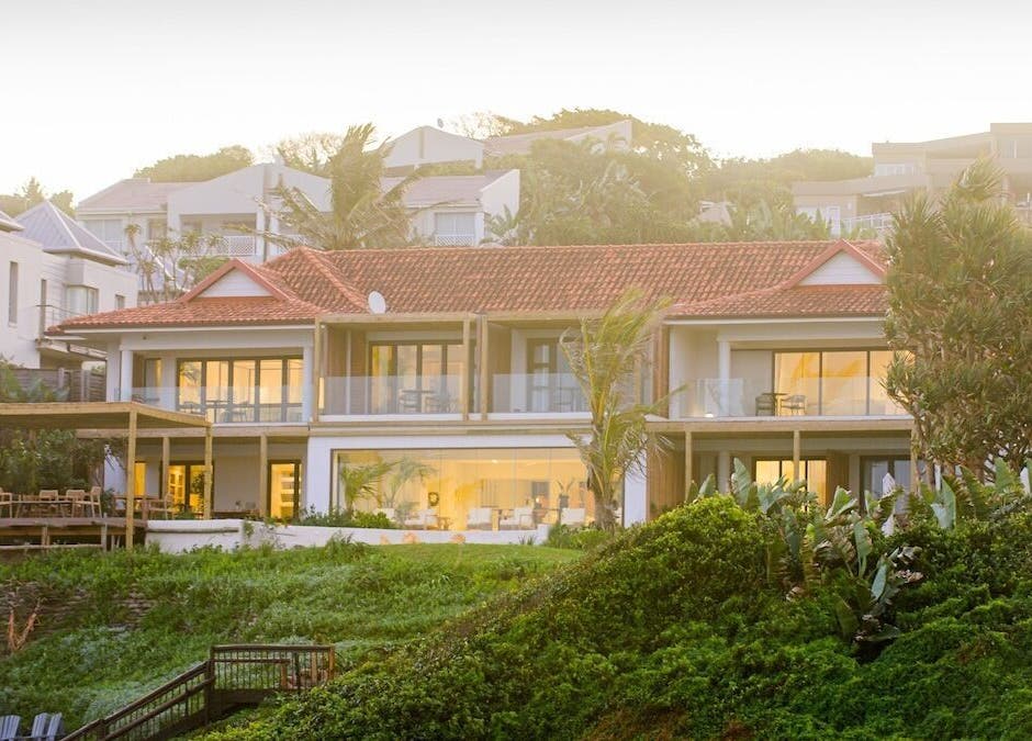 Sala Beach Spa exterior at sunrise in Dolphin Coast, KwaZulu-Natal, ZA, surrounded by lush greenery.