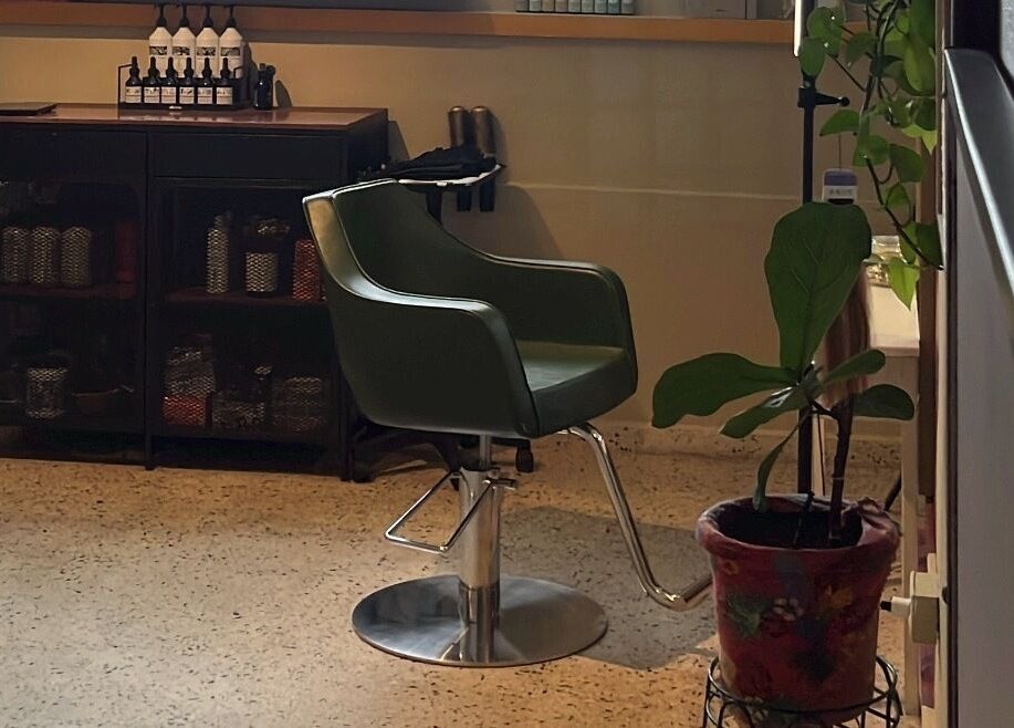 Silla estilista en Dejame Hacer tu Cabello, Arecibo, Arecibo, PR, junto a productos y planta decorativa.