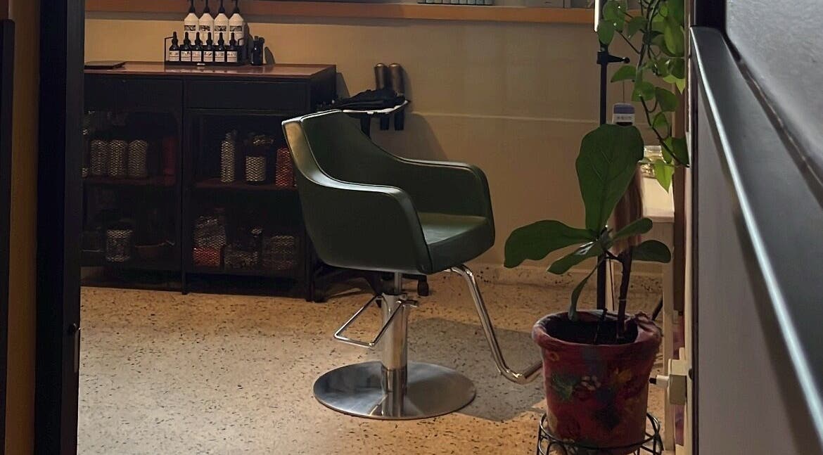 Silla estilista en Dejame Hacer tu Cabello, Arecibo, Arecibo, PR, junto a productos y planta decorativa.