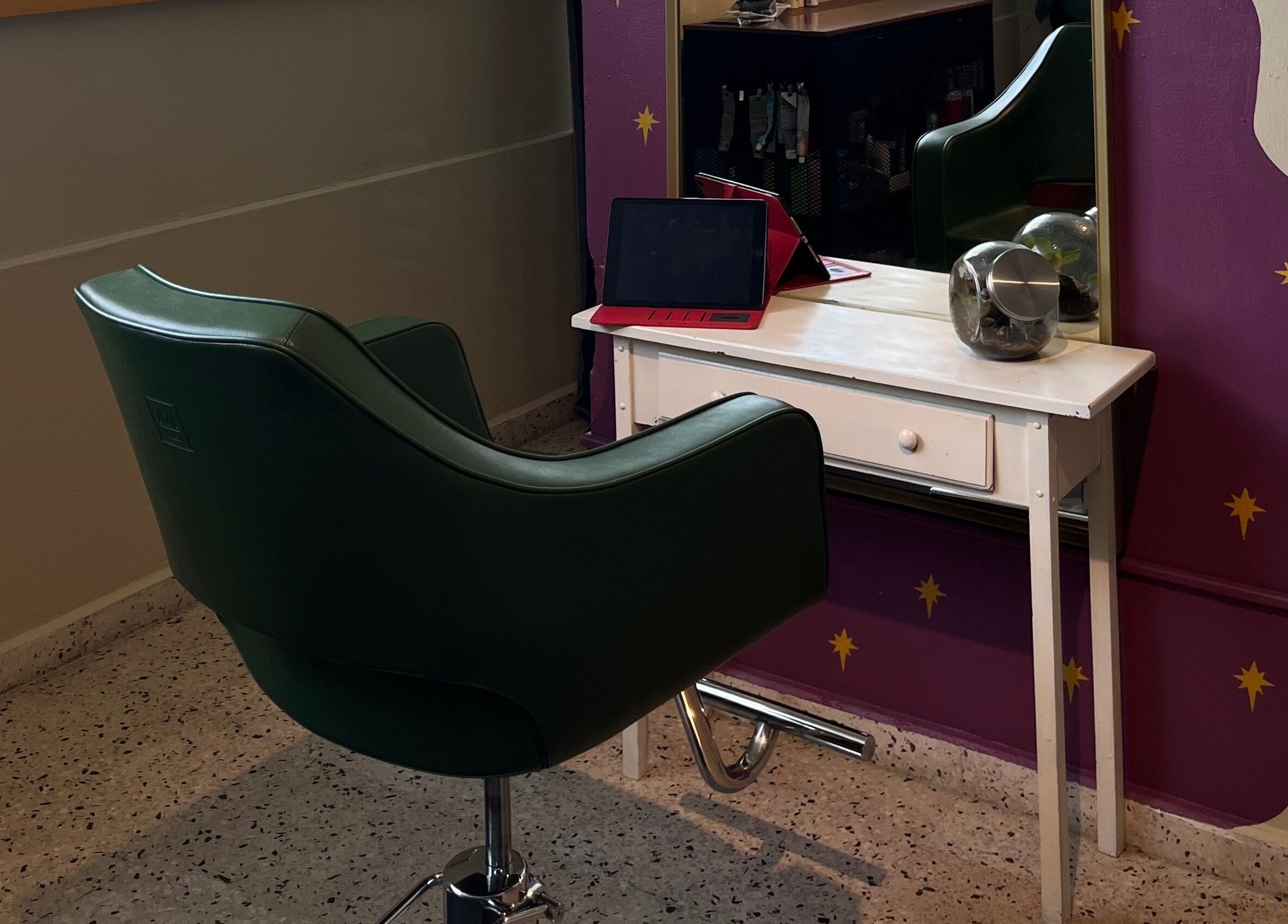 Estación de peluquería en Dejame Hacer tu Cabello, Arecibo, Arecibo, PR con silla verde y espejo púrpura.