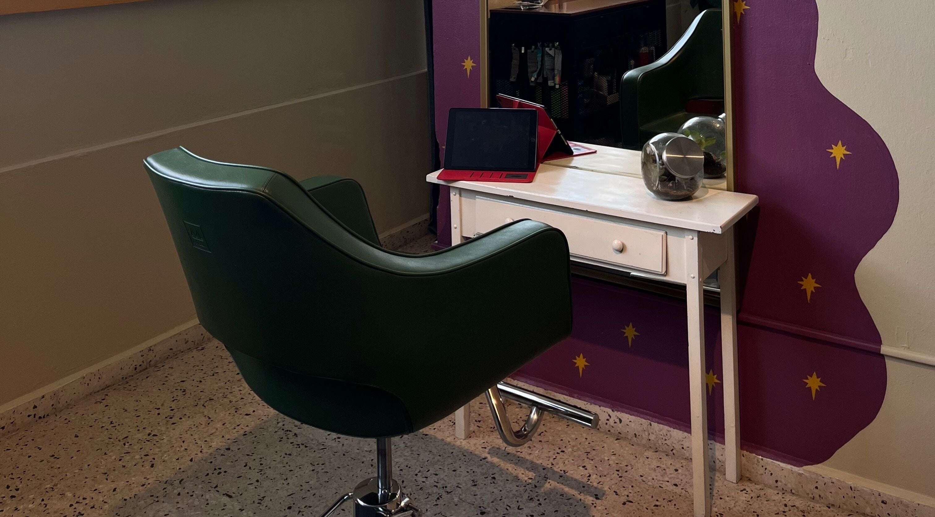 Estación de peluquería en Dejame Hacer tu Cabello, Arecibo, Arecibo, PR con silla verde y espejo púrpura.