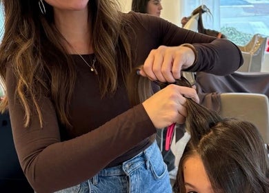 Hairstylist at RèFINE Boutique Salon in Morton Grove, Illinois, US, working on a client's hair.
