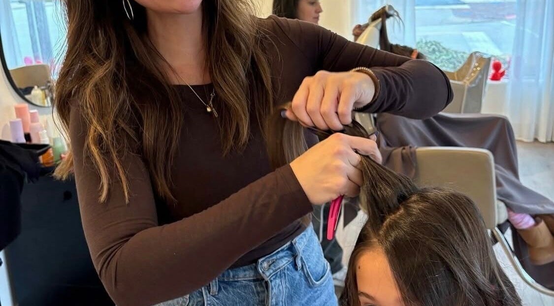 Hairstylist at RèFINE Boutique Salon in Morton Grove, Illinois, US, working on a client's hair.