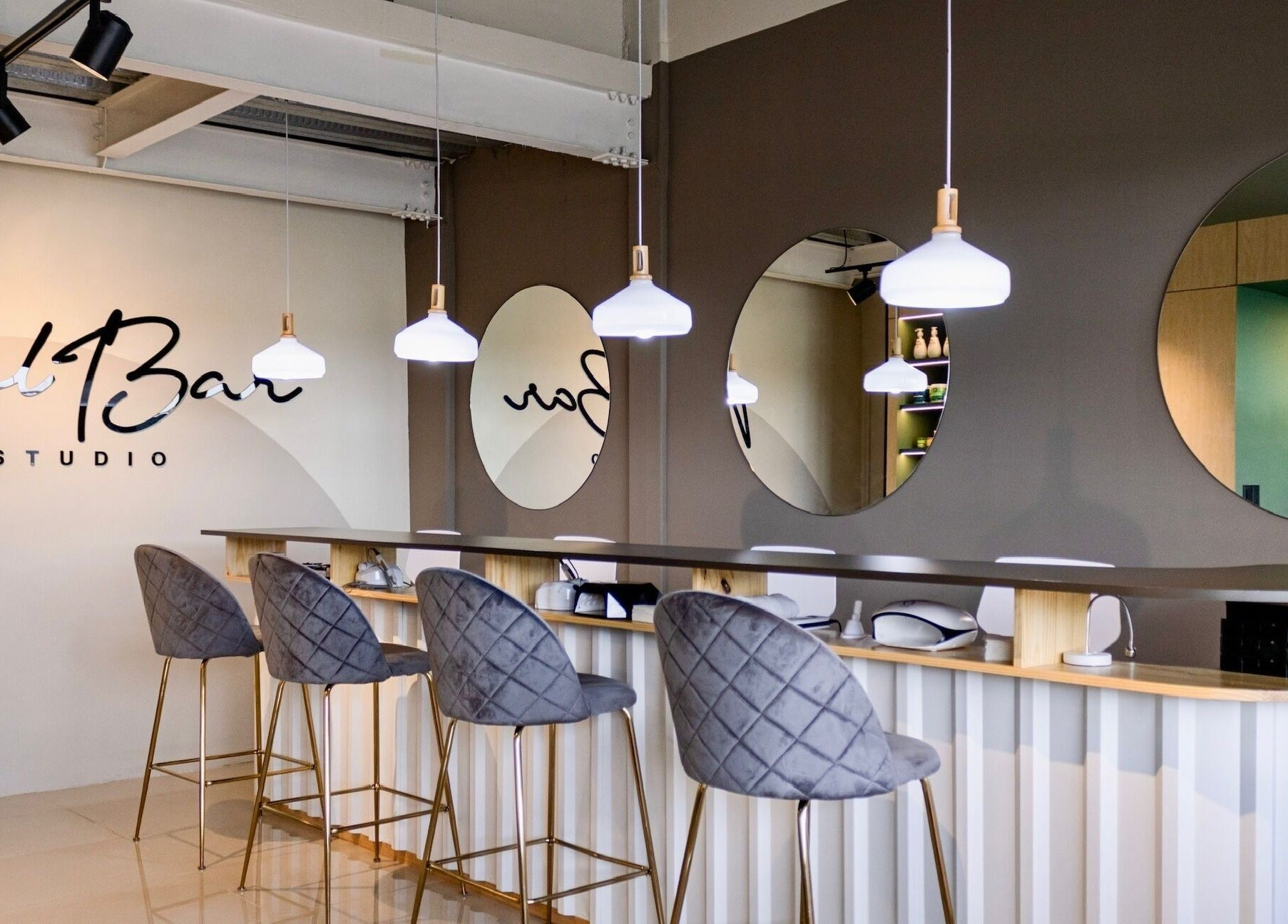 Interior moderno de Nail Bar Plaza Pinula en Guatemala, Guatemala, GT con sillas grises y espejos circulares.