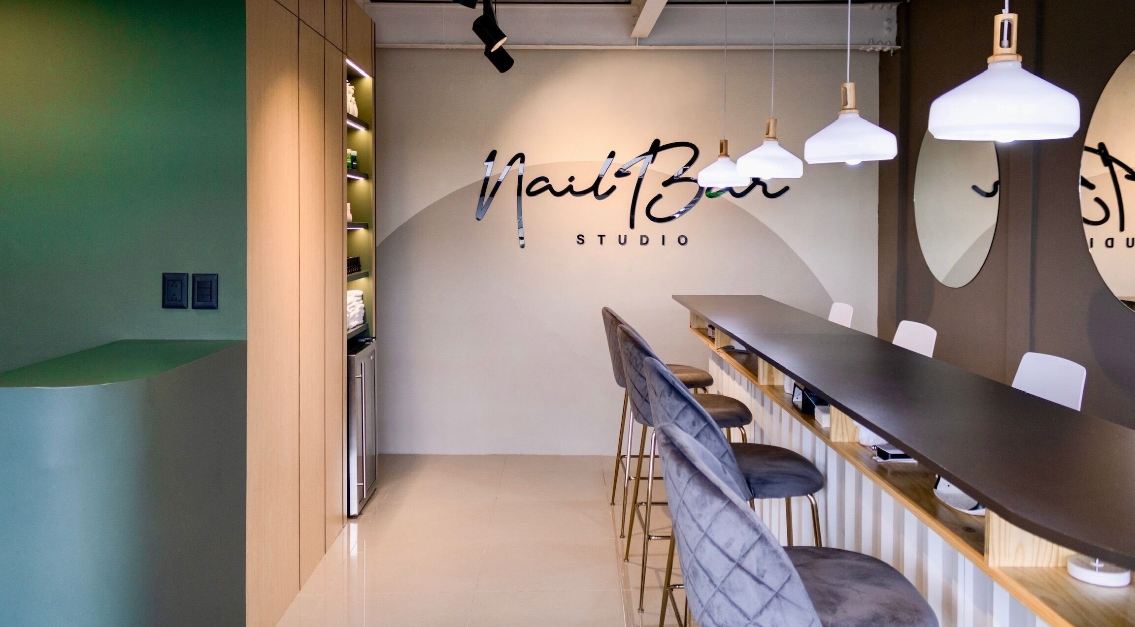 Interior moderno de Nail Bar Plaza Pinula en Guatemala, Guatemala, GT con sillas elegantes y luces colgantes.