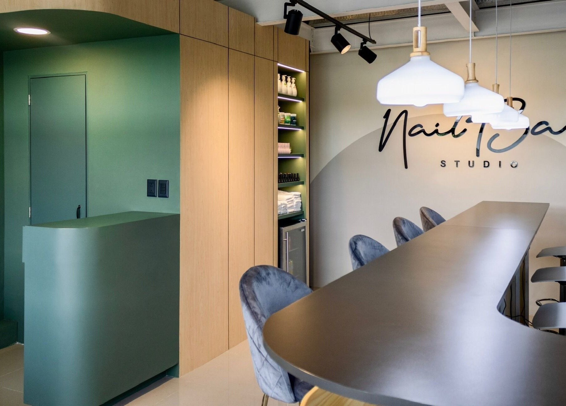 Interior moderno de Nail Bar Plaza Pinula, Guatemala, Guatemala, GT, con un mostrador verde y sillas de diseño.