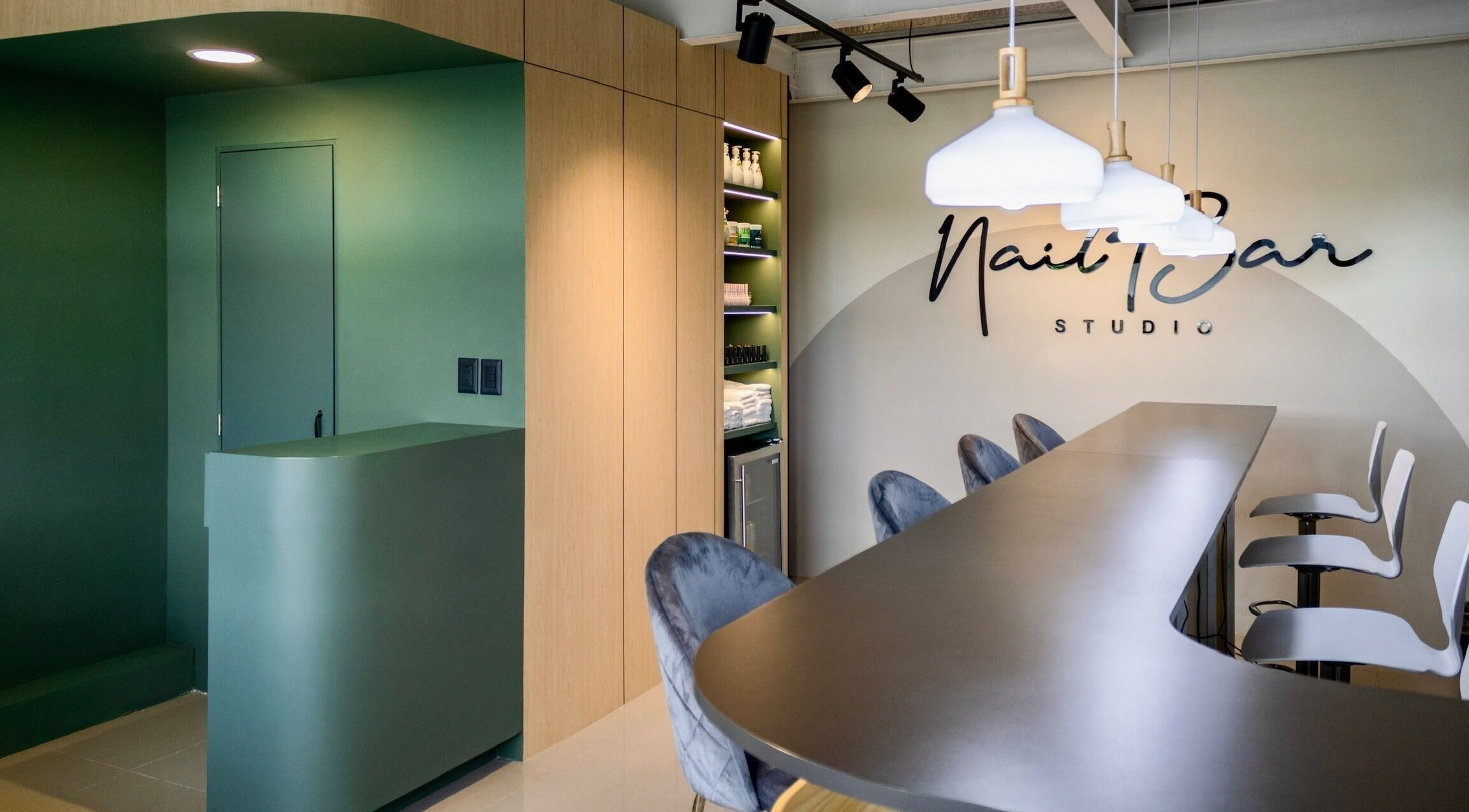 Interior moderno de Nail Bar Plaza Pinula, Guatemala, Guatemala, GT, con un mostrador verde y sillas de diseño.
