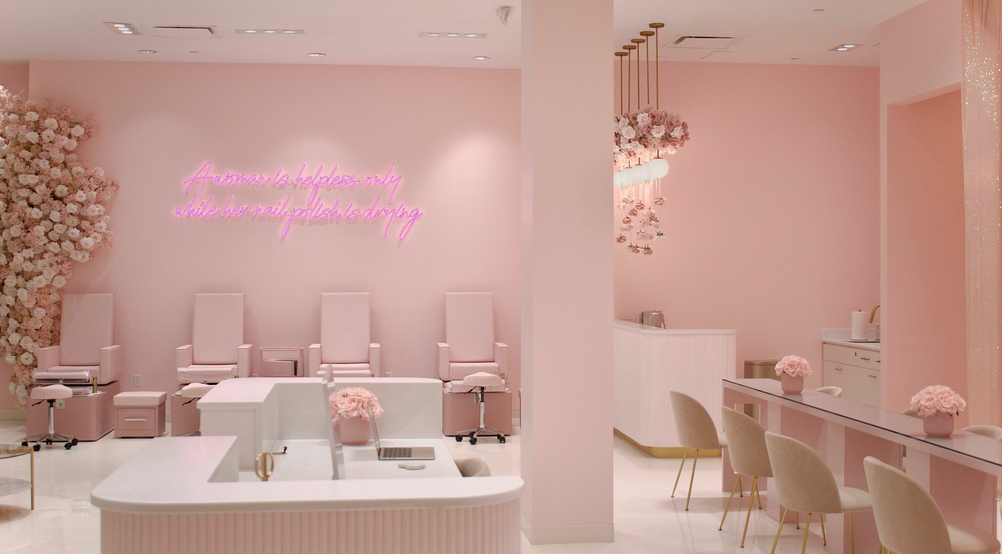 Elegant pink nail salon at Nail'd It London, Los Angeles, California, US with chic seating and floral decor.