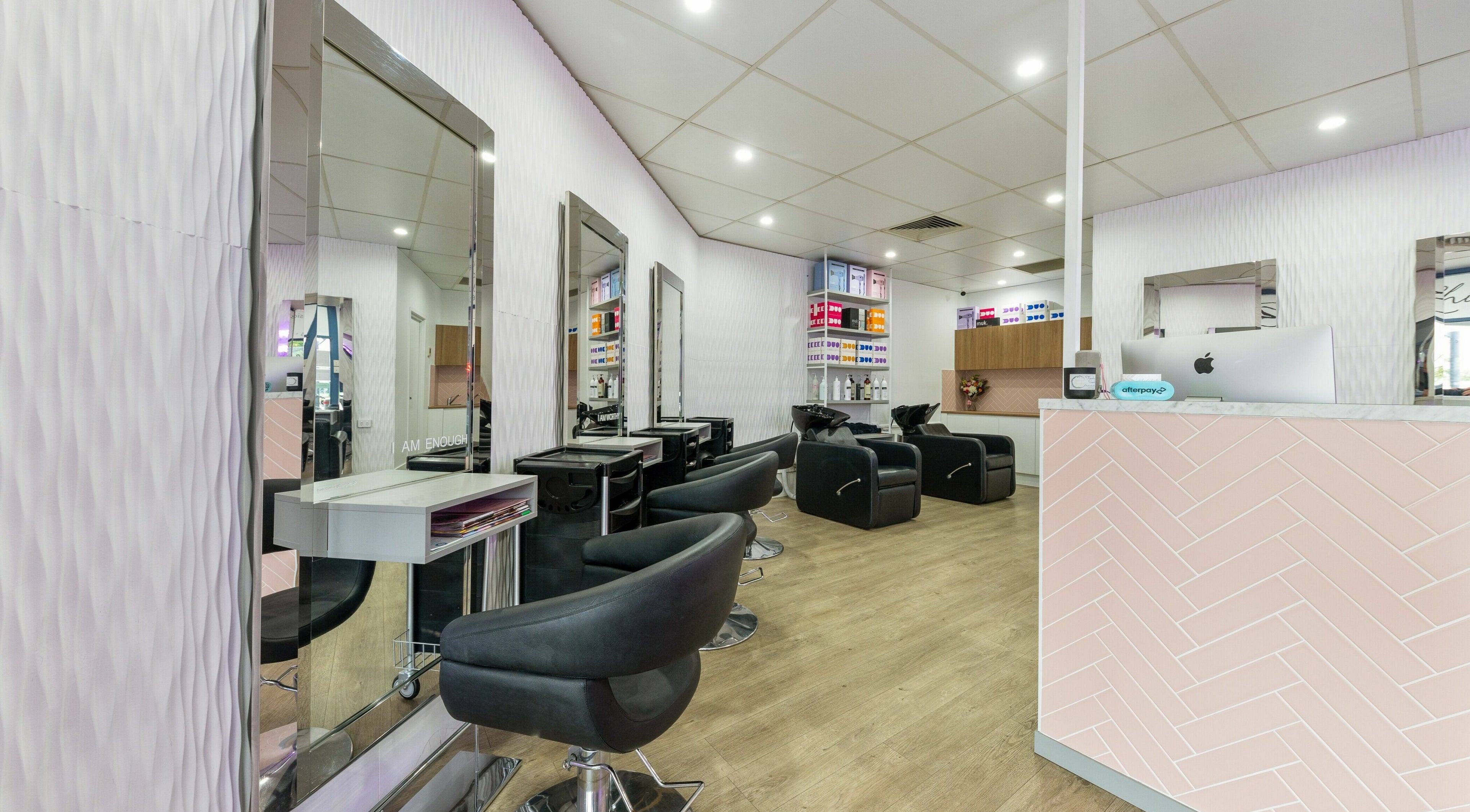 Modern, bright salon interior at Rhi-Style Hair Salon, Varsity Lakes, Queensland, AU with sleek black chairs.